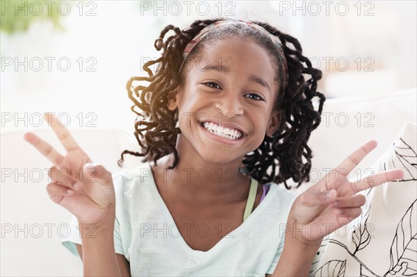 Smiling Black girl making peace sign