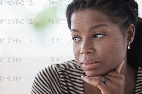 Black woman resting chin in hand
