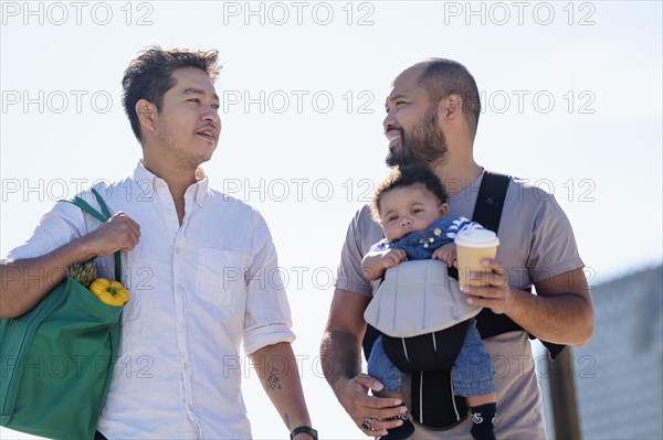 Gay fathers doing errands with baby son