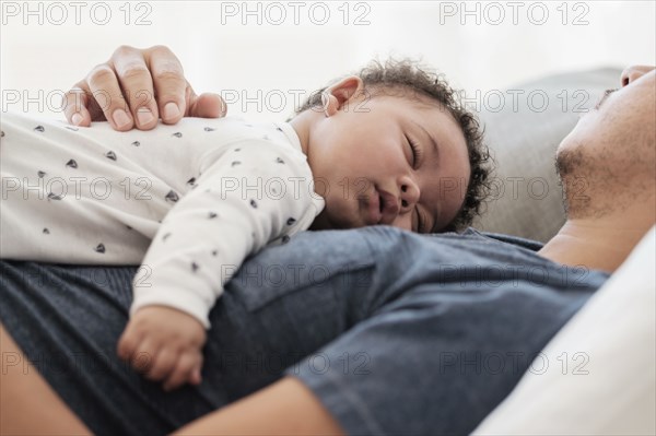Father and baby son sleeping on bed