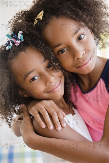 Mixed race sisters hugging