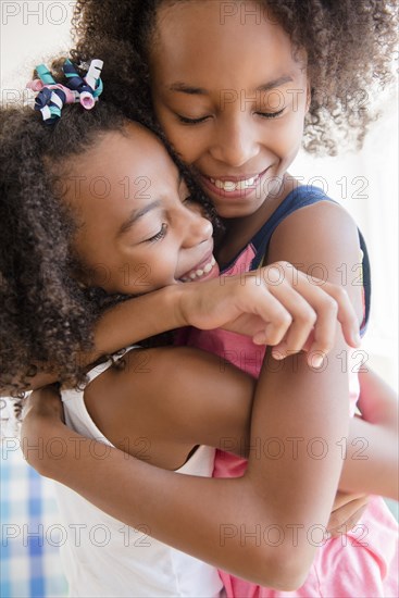 Mixed race sisters hugging