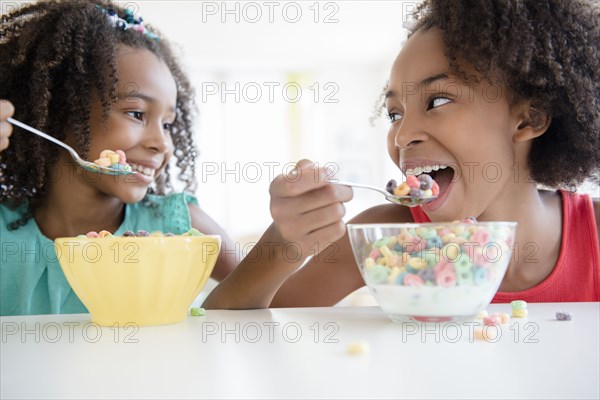 Mixed race sisters eating cereal
