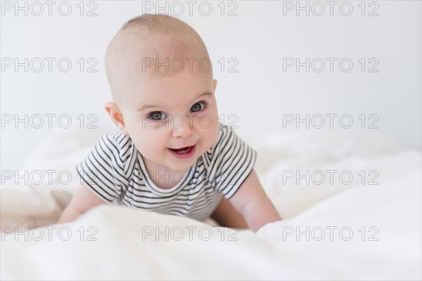 Caucasian baby girl crawling on bed