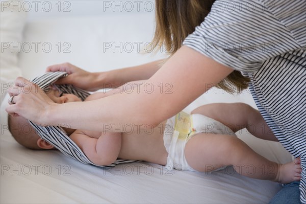 Caucasian mother changing baby diaper