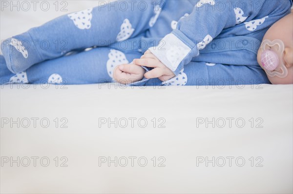 Caucasian baby girl laying on bed