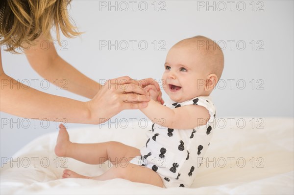 Caucasian mother and baby daughter on bed