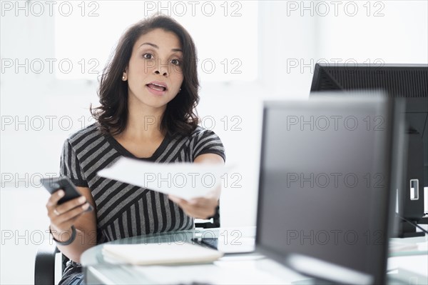 Mixed race businesswoman working at desk