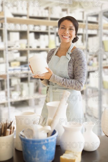 Mixed race potter smiling in workshop