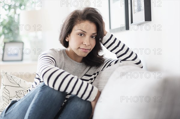 Mixed race woman sitting on sofa