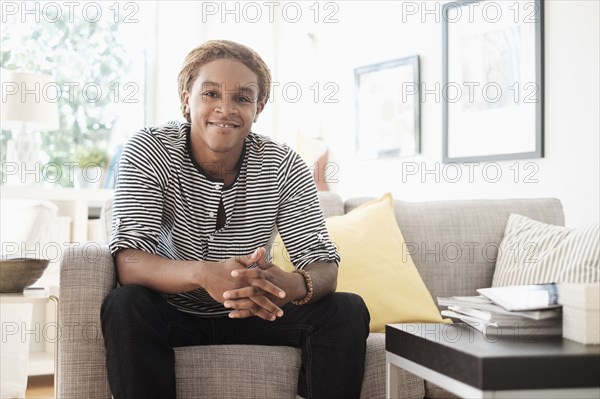 Mixed race man sitting on sofa