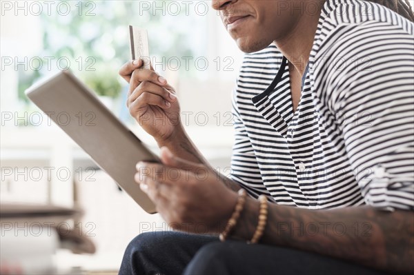 Mixed race man shopping online with digital tablet