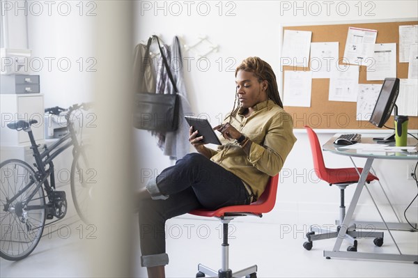 Mixed race businessman using digital tablet in office