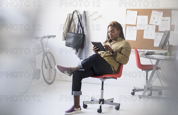 Mixed race businessman using digital tablet in office