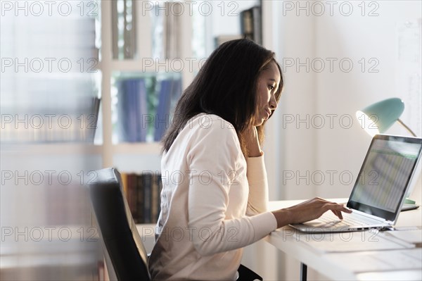 Mixed race businesswoman using laptop