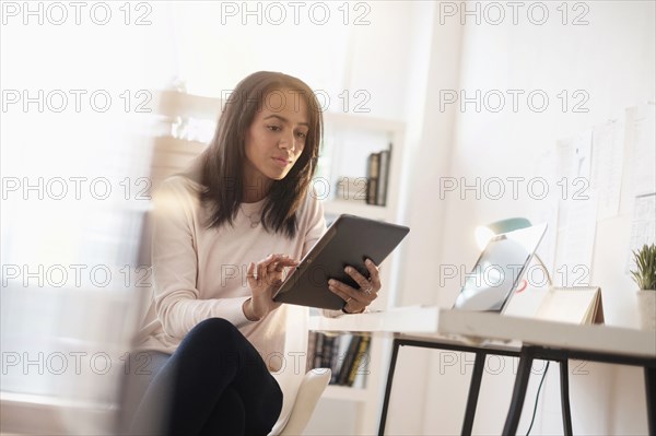 Mixed race businesswoman using digital tablet