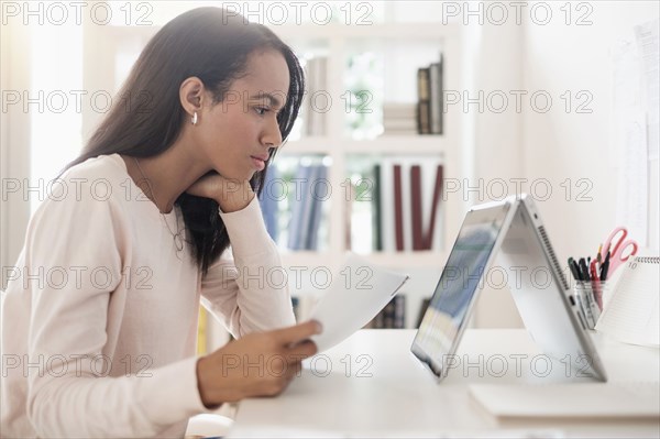 Mixed race businesswoman using laptop