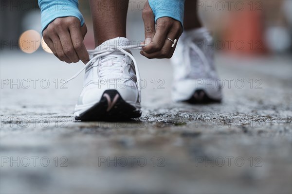 Mixed race runner tying shoelaces