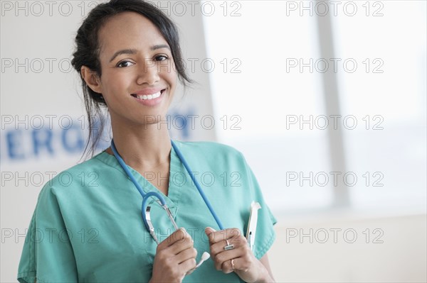 Mixed race nurse smiling in hospital