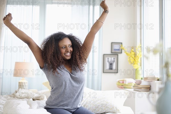 Black woman stretching on bed