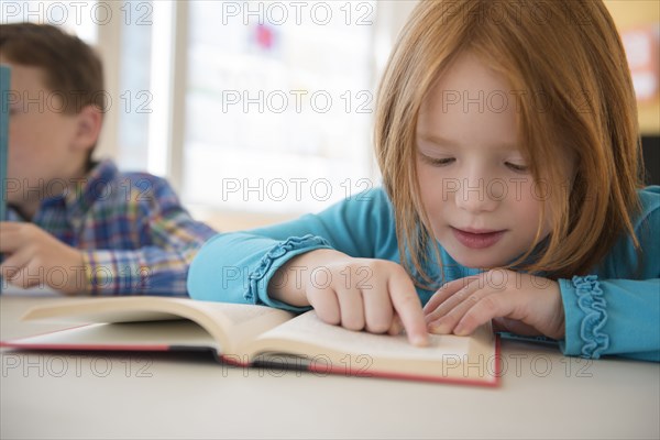 Caucasian student reading in classroom