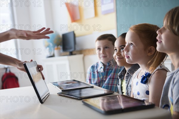 Teacher demonstrating digital tablet for students