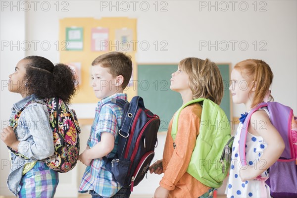 Students wearing backpacks in classroom