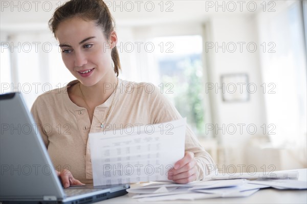 Native American woman paying bills on computer