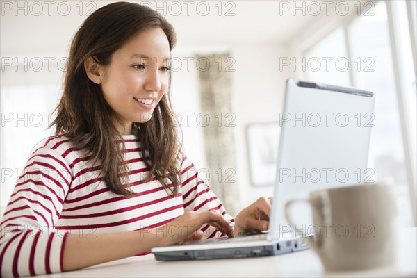 Mixed race woman using laptop