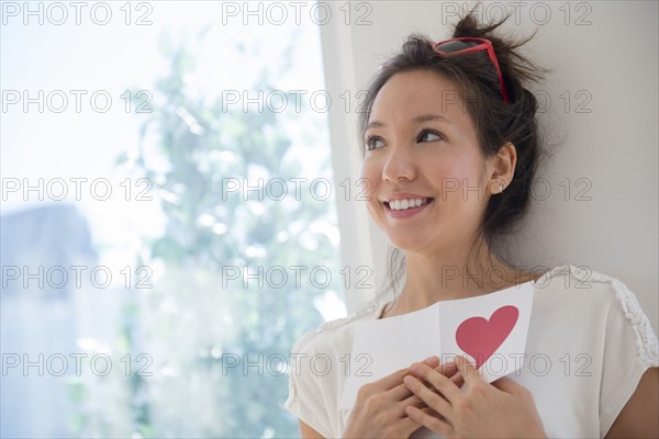 Mixed race woman holding Valentine card