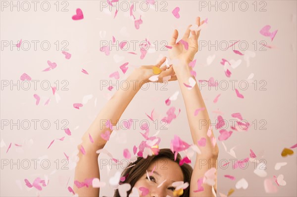 Mixed race woman playing in confetti