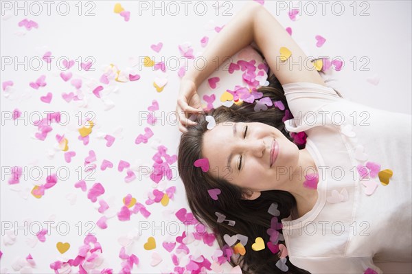 Mixed race woman playing in confetti