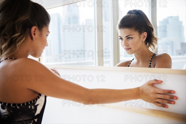 Mixed race dancer examining herself in mirror