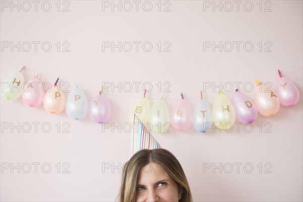 Caucasian woman wearing party hat at birthday