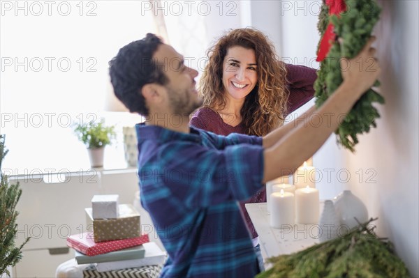 Couple hanging Christmas wreath