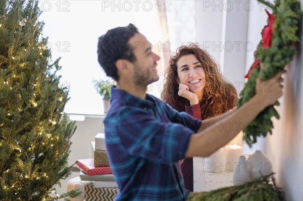 Couple hanging Christmas wreath