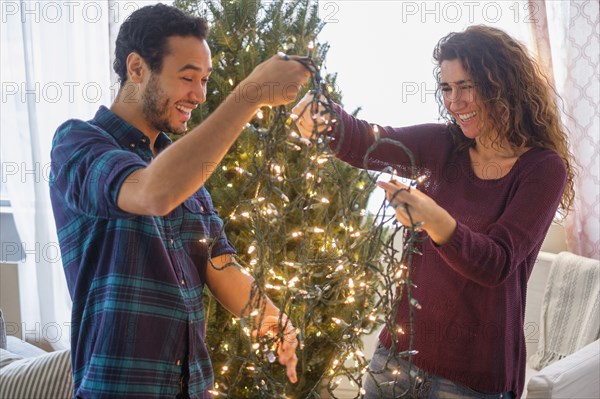 Couple decorating Christmas tree