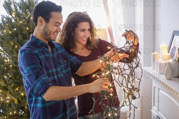 Couple untangling Christmas lights