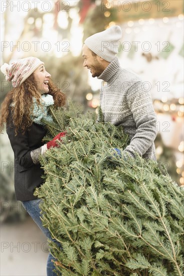 Couple hauling tree at Christmas tree farm