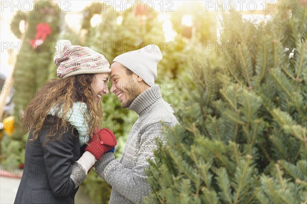 Couple hugging at Christmas tree farm