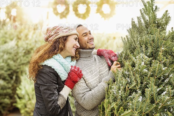 Couple hugging at Christmas tree farm