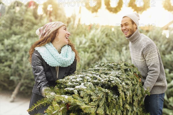 Couple hauling tree at Christmas tree farm