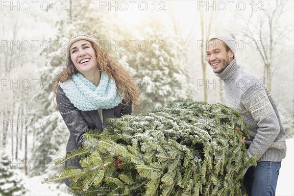 Couple hauling tree at Christmas tree farm