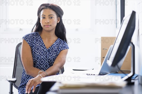 Mixed race businesswoman sitting at desk