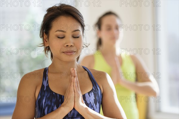 Women practicing yoga in studio