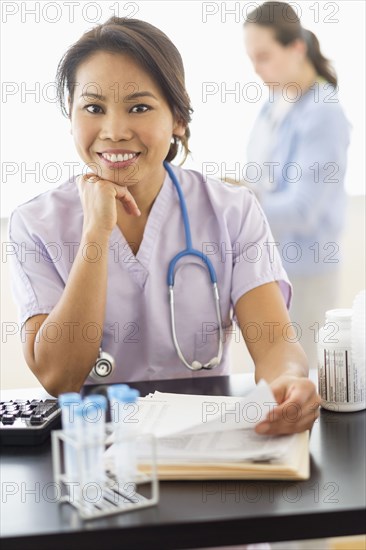 Nurse smiling at desk in hospital