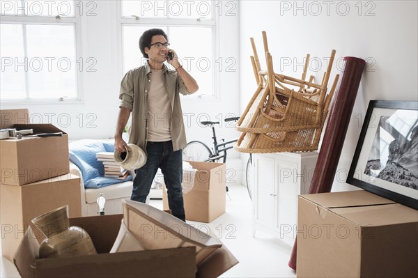 Mixed race man unpacking in new home