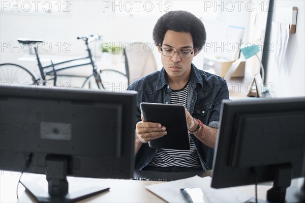 Mixed race businessman using digital tablet in office