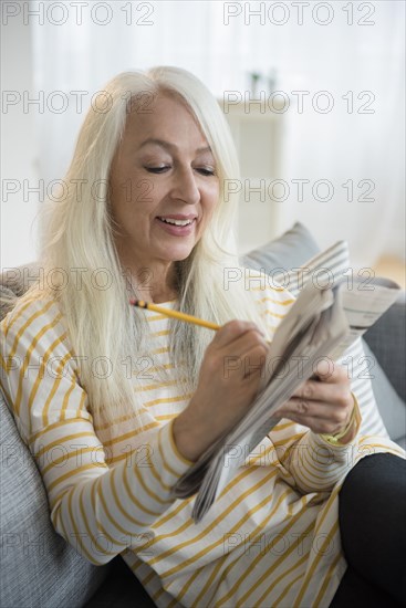 Caucasian woman doing crossword puzzle