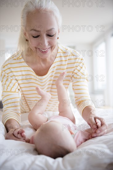 Caucasian grandmother admiring baby granddaughter